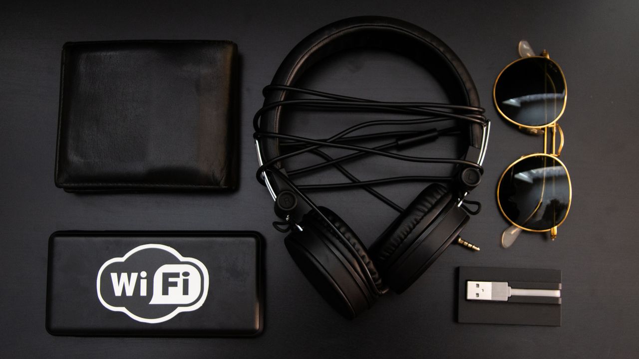 portfolio-04 A stylish arrangement of essential accessories including headphones, wallet, and sunglasses on a black surface.